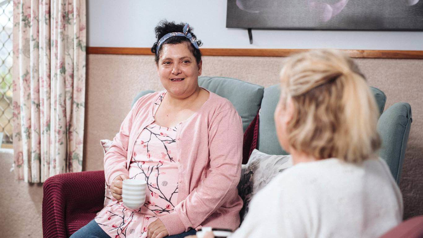 Brightwater Positive Behaviour Support Services_disability client sitting down to go over her goals with support staff worker