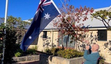 Brightwater resident John East raises the Australian flag