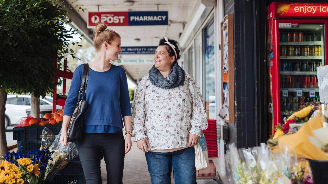 Brightwater Dietitian Services_support worker with disability client out walking in Perth suburbs with florist and post office in background