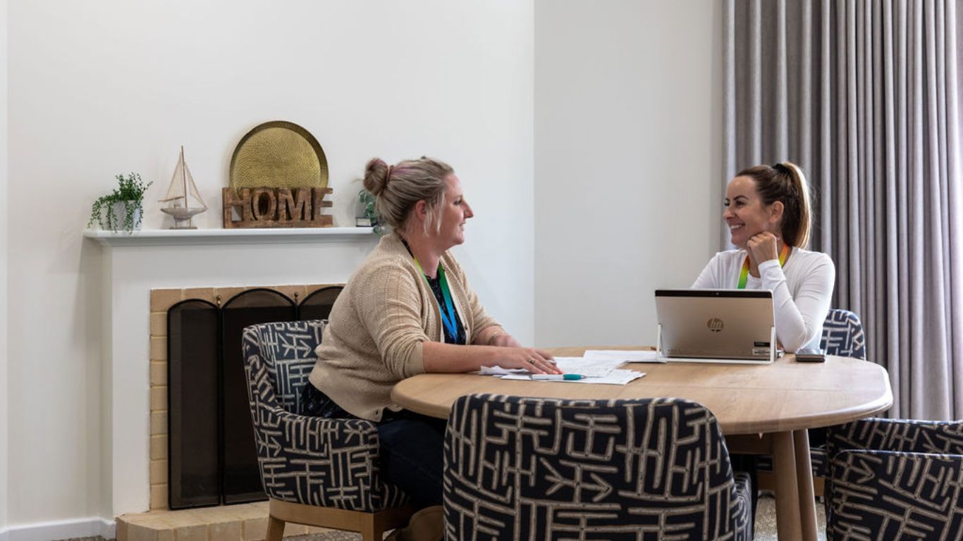 Brightwater Neurological Conditions_staff sitting together with paperwork for meeting inside disability unit